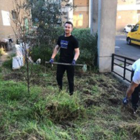 Young man gardening in overgrown grassy area