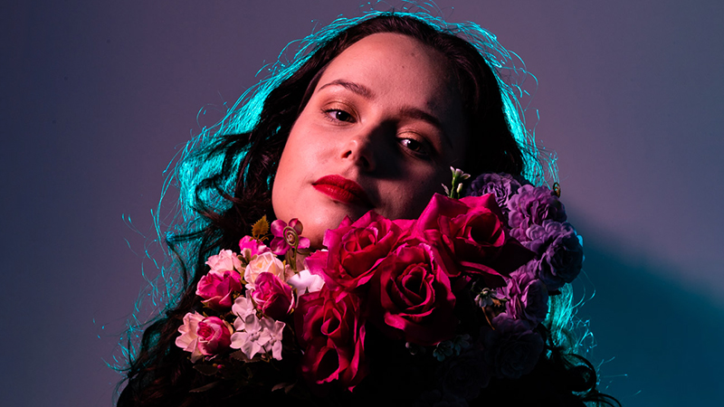 Female holding bunch of beautiful flowers in romantic, gentle lighting