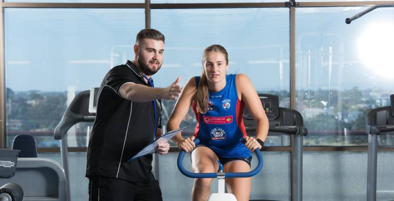  	VU student, Western Bulldogs AFLW ambassador Ellyse Gamble on an exercise bike