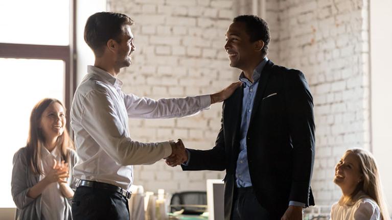  A handshake between employees, contributing to a positive work environment.