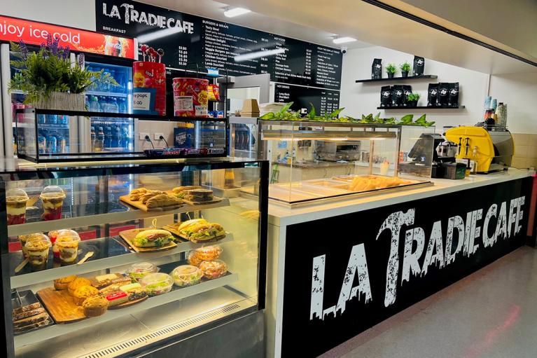 A cafe with sandwich bar and sign 'La Tradie Cafe'