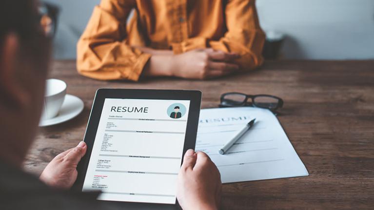  Person holding resume during job interview.