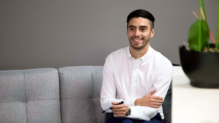  VU psychology graduate Eduardo sitting in a counselling room.