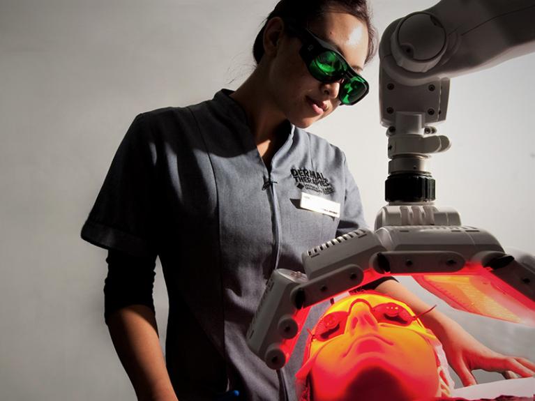  Student using laser technology for skin treatment.