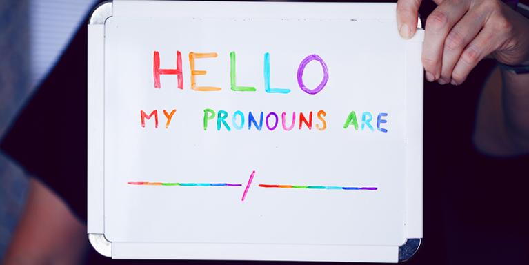  A white board that says "hello my pronouns are".