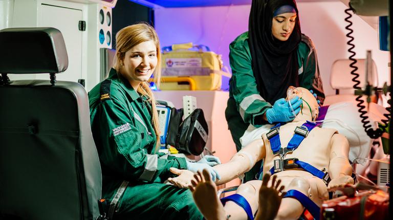  students practising on a dummy in an ambulance