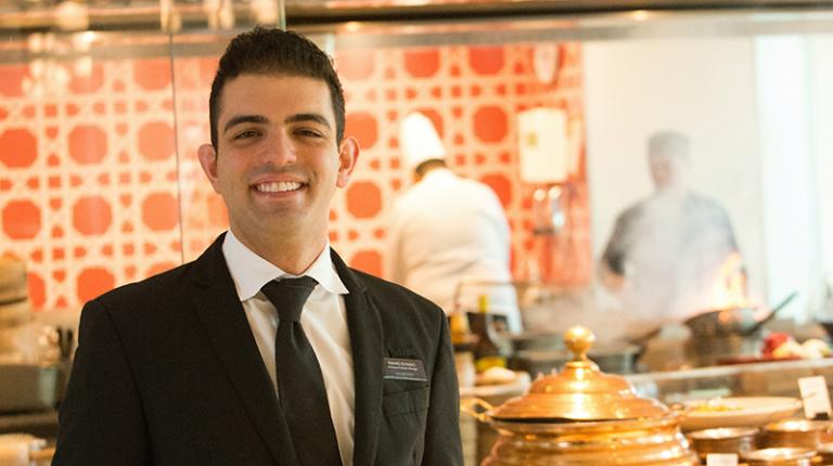 A tourism and hospitality staff member smiles at work.