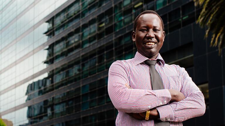 Man dressed professionally in front of city building