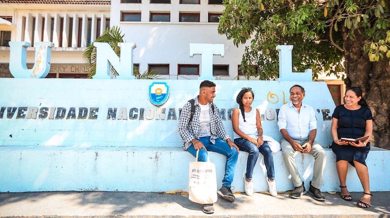 Four people sitting outside the UNTL campus