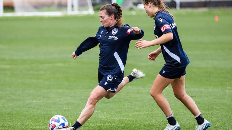 Female Melbourne Victory players training on pitch