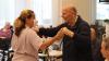 An elderly man dances with a carer