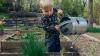  Child waters plats in a garden