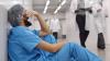 Healthcare workout experiencing burnout in a hospital corridor.