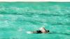 Man swims in a pool near the ocean