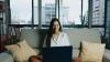  Young woman on couch looking at laptop