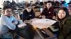 Four university students of diverse background with paper project plans