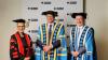 Linda Dessau, Steve Bracks and Adam Shoemaker in gowns and hats.